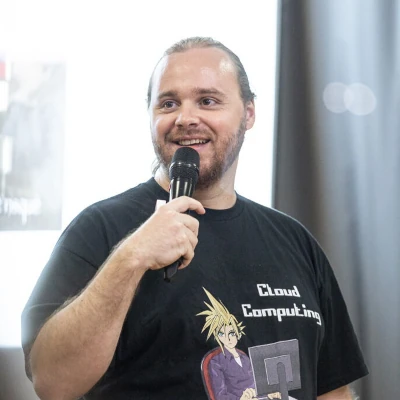 Photo de Julien avec un micro, un T-Shirt noir avec l'inscription Cloud Computing